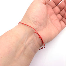 red cord bracelet around a wrist