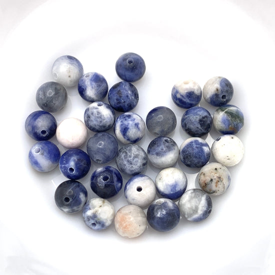 round jewelry beads that are tan, blue, orange