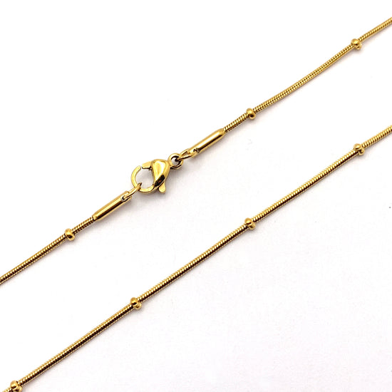 gold colour metal necklace with beads on it and lobster claw clasp