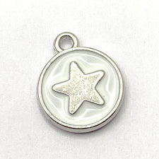 close up of round white jewelry charms with silver star on them