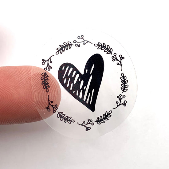 black and clear sticker that has a heart and leaves on it