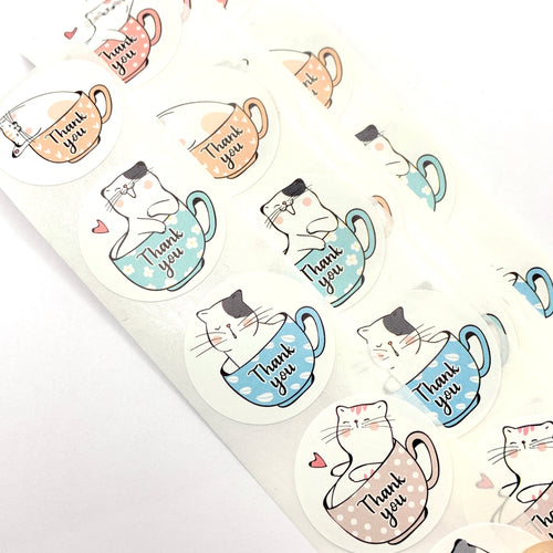 Colourful round stikers with kittens in teacups with the words thank you on them