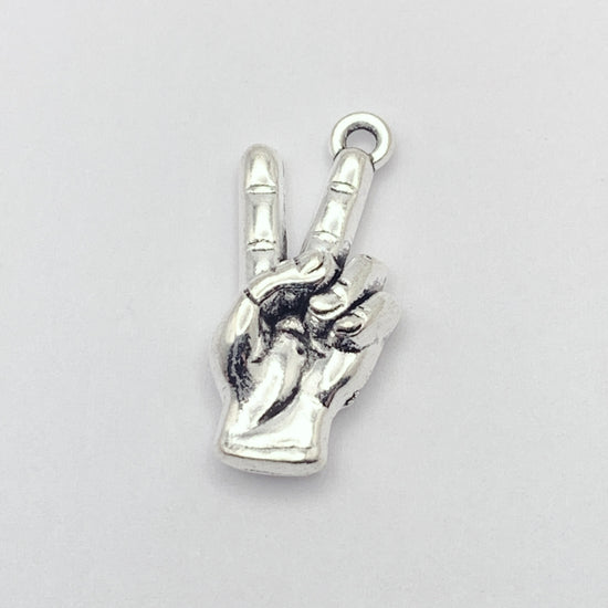 silver jewelry charm that looks like a hand giving "peace" symbol