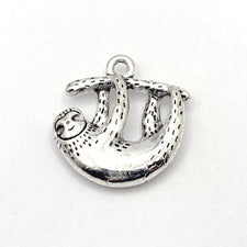 silver jewelry charm that look like a sloth holding onto a branch