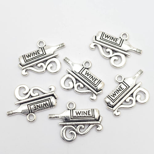 Six silver colour jewelry charms that are shaped like a bottle with the word "wine" etched into them