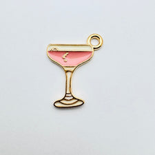 pink and gold jewelry charm that looks like a drink