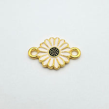 White and gold connector jewelry charm that looks like a daisy flower