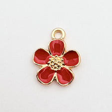 Red and gold jewelry charm in the shape of a five petal flower