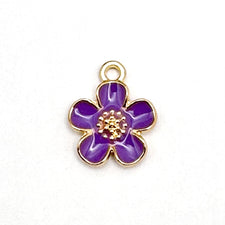 Purple and gold jewelry charm in the shape of a five petal flower