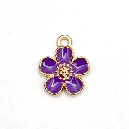Purple and gold jewelry charm in the shape of a five petal flower