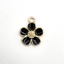 Black and gold jewelry charm in the shape of a five petal flower