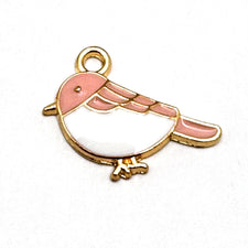 pink white and gold jewelry charm in the shape of a bird
