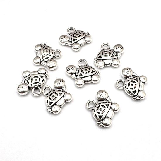 silver colour jewelry charms that look like tortoises