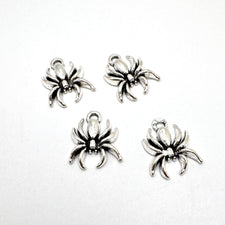 silver colour jewelry charms in the shape of spiders