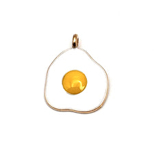 white yellow and gold jewerly charm that looks like a fried egg