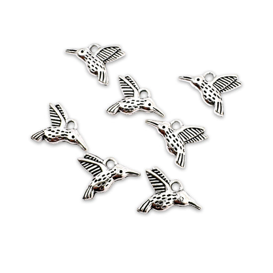 silver colour jewerly charms that look like hummingbirds