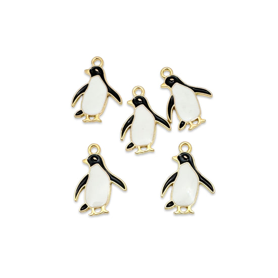 black white and gold jewelry charms that look like penguins