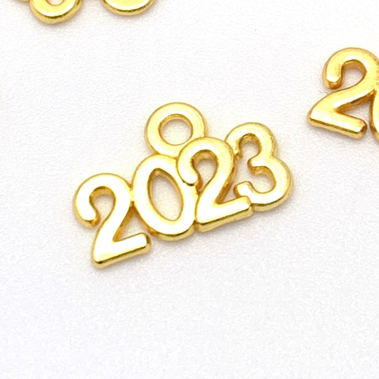 gold colour jewerly charms that say 2023