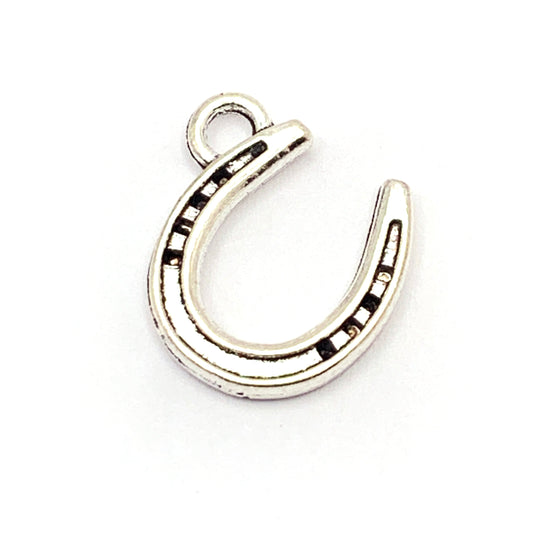 silver colour jewerly charm in the shape of a horseshoe