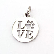 round silver jewerly charm with the word "love" on it, the o being a paw print