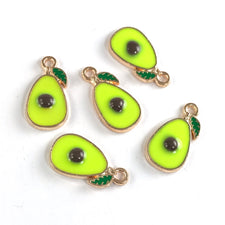 green and gold jewerly charms that look like avocodo halves