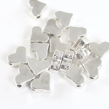 pile of silver jewerly beads shaped like hearts