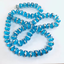 string of round jewelry beads that are light blue with silver stripe