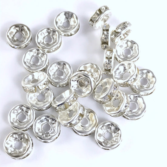 25 jewelry beads that are silver in colour with clear rhinestones