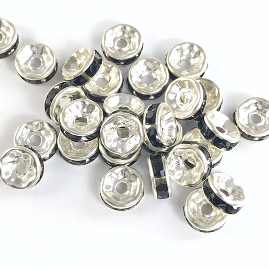 25 jewelry beads that are silver in colour with black rhinestones
