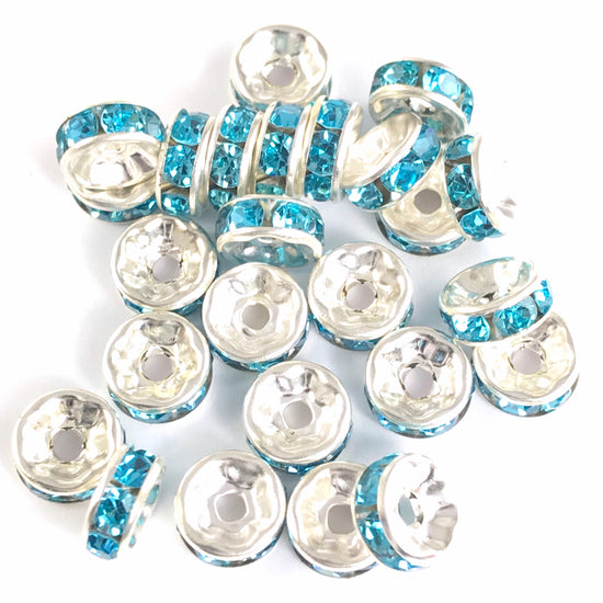 25 jewelry beads that are silver colour with blue rhinestones