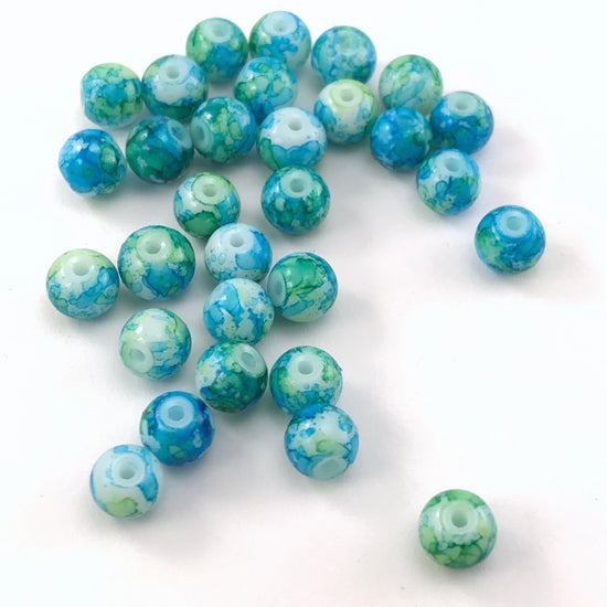 jewelry beads that have a green and blue marble pattern