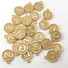 Beige and gold round charms with letters on them