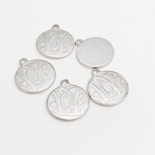 silver colour jewelry charms that have Love stamped on them