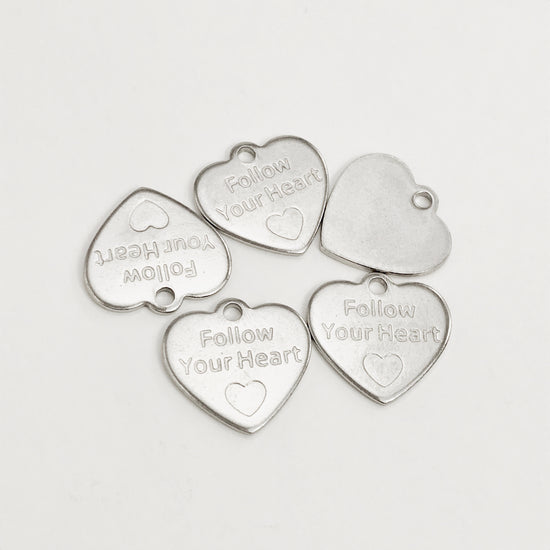heart shaped silver jewelry charms that have follow your heart stamped on them