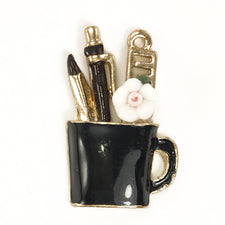 jewelry charms that look like a black cup with tools in the cup