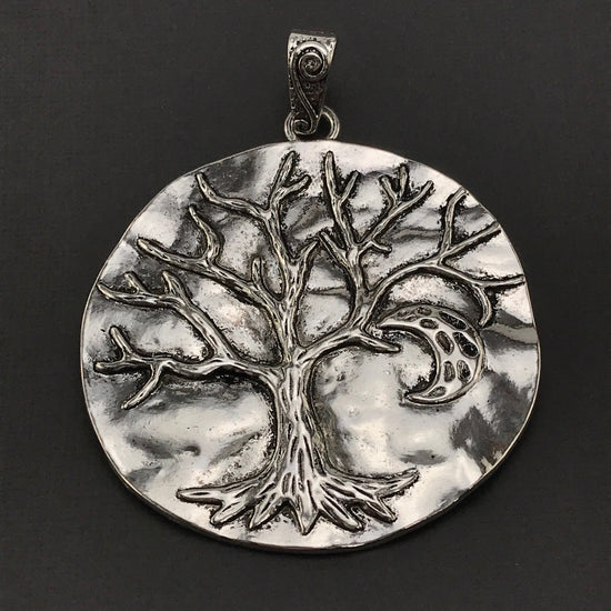 large silver jewelry pendant with tree of life on it
