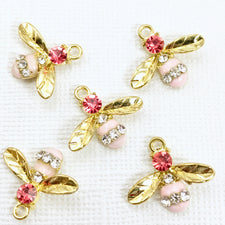 5 gold and pink jewelry charms that look like bees