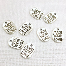 oval silver jewelry charms that have made with love stamped on them
