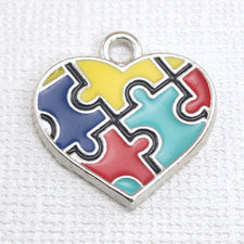 jewelry charm that is silver with multi color puzzle piece pattern