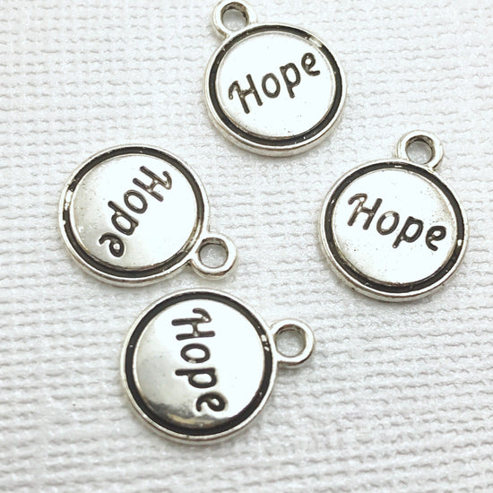 silver jewelry charms with the word hope on them