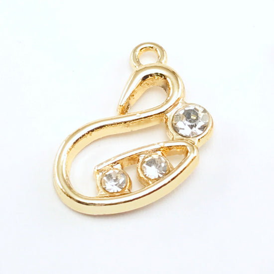 gold colour jewelry pendant that is shaped like a swan