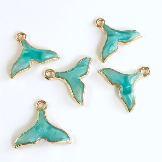 5 jewelry charms shaped like whale tails, turquoise colour