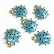 5 jewelry charms that look like ladybugs, blue and gold in colour