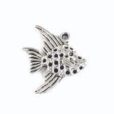 close up of a silver jewelry charm that looks like a fish