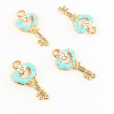 5 jewelry charms that are shaped like keys, blue and gold colour