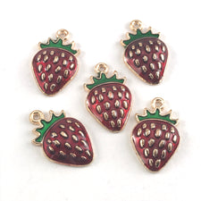 gold, red and green jewerly charms that look like strawberries
