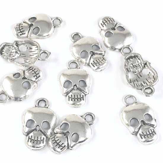 silver colour jewelry charms that look like skulls
