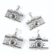 four silver colour jewerly charms that look like cameras