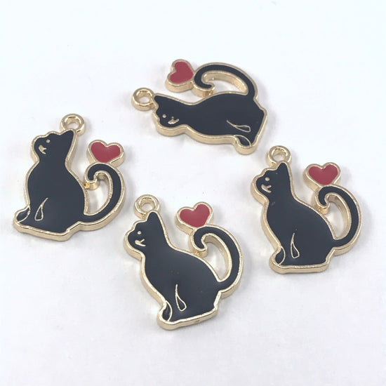 4 black and gold jewelry charms that are shaped like cats