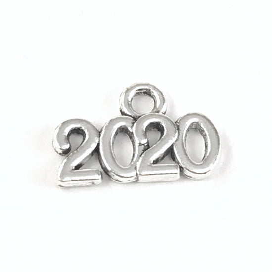 close up of a silver jewelry charm that says 2020